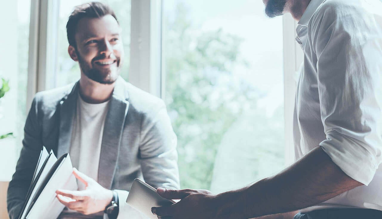 Man smiling and holding folder