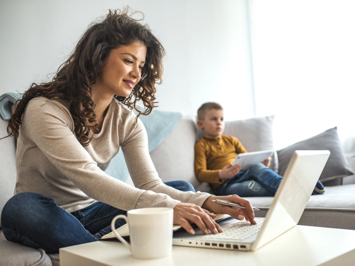Woman working from home with child in background