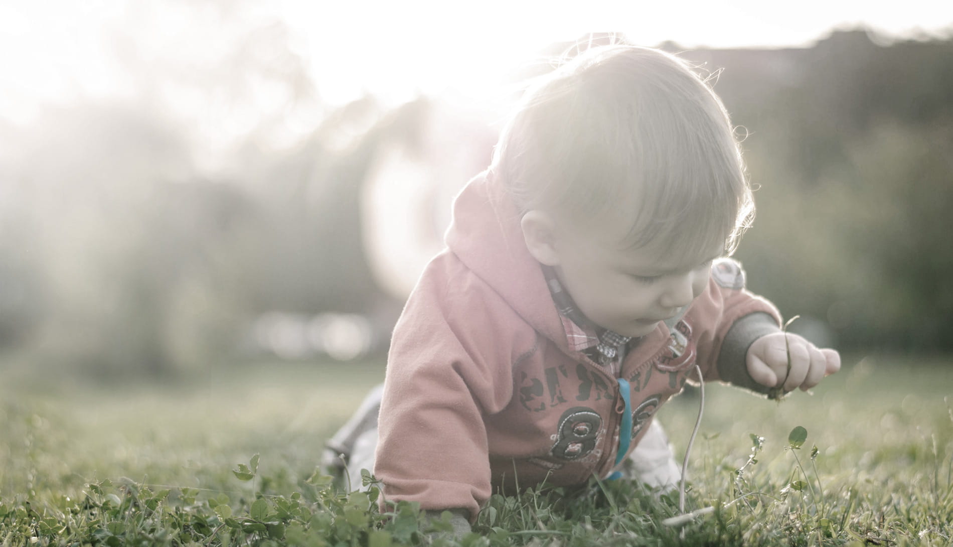 Young boy crawling outside